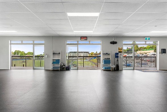 Open-plan interior of the College Rifles pavilion with views over the playing field